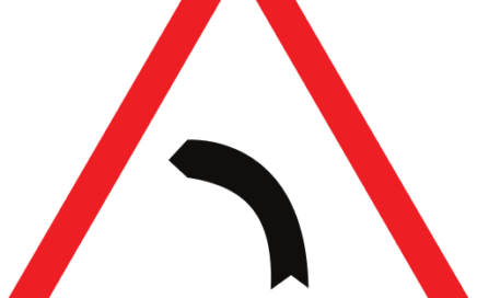Señal vertical de advertencia de peligro por la proximidad de una curva peligrosa hacia la izquierda